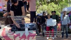 Con cartulina en mano, mamá y papá apoyan a su hijo DJ en un festival de música