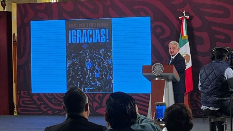 El Presidente muestra la portada de su libro en una conferencia de prensa.