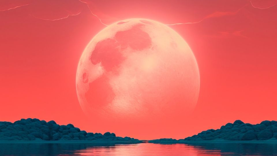 Una inmensa Luna detrás de un tranquilo lago.