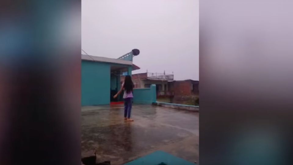 La niña bailaba bajo la lluvia en el patio de su casa, ubicada en uno de los barrios de Sitamarhi, en India.