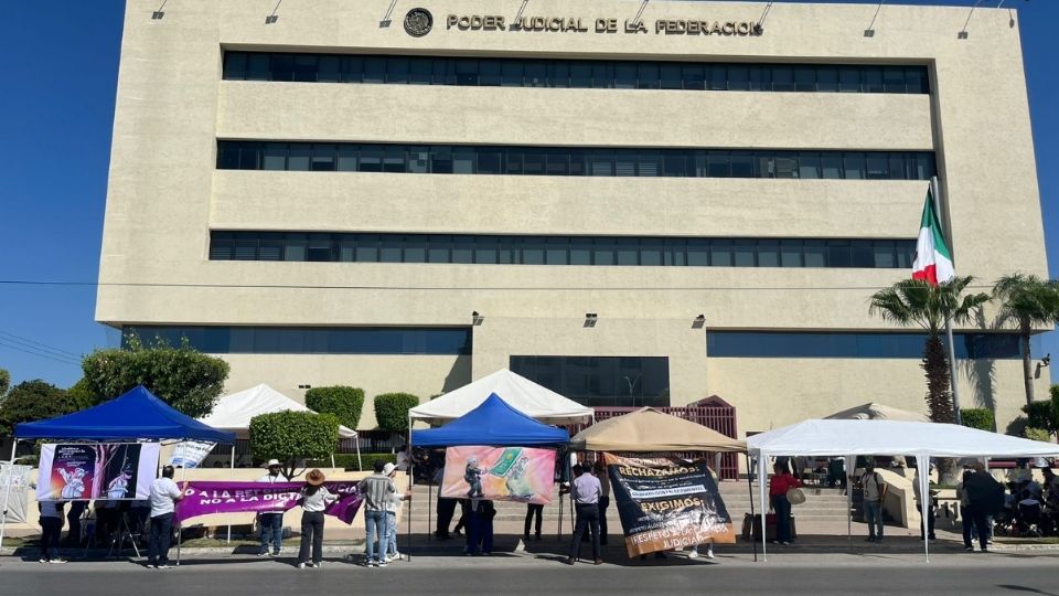 Manifestantes permanecen a las puertas de su centro de trabajo.