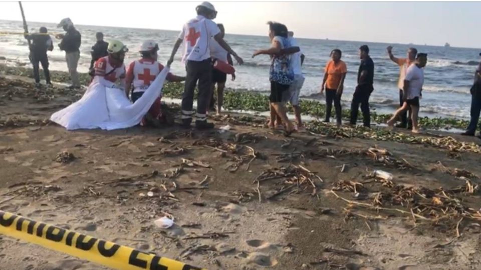 Mueren ahogados adolescente y tío en playa de Veracruz. En la foto, un familiar hace el reconocimiento de los fallecidos