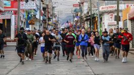 Foto que representa a Presidenta municipal sale correr resguardada de policías fuertemente ARMADOS